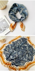 Close-up of navy and orange paisley silk scarf with glossy texture and floral patterns