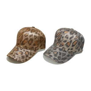 Close-up of metallic leopard print baseball caps in gold and silver textured finish