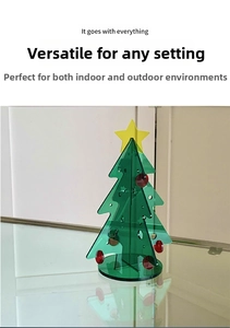 Close-up of green acrylic Christmas tree desktop ornament with yellow star and red dots
