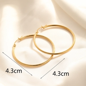 Detailed view of 4.3cm golden hoop earrings with elegant diamond-cut textured finish