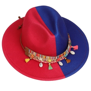 Detail view of red and blue wool fedora with bohemian fringe and shell decorative band