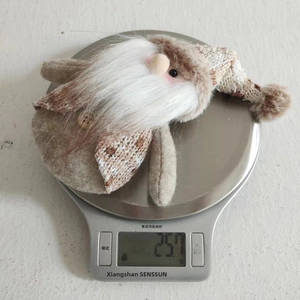 Christmas gnome plush ornament on a digital scale showing a weight of 25.7g for shipping