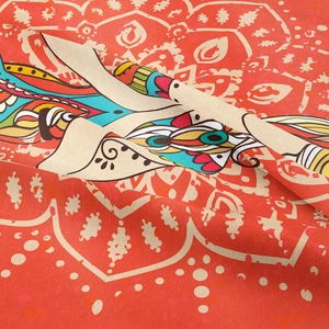 Detail of bohemian mandala tapestry featuring intricate orange and red woven patterns