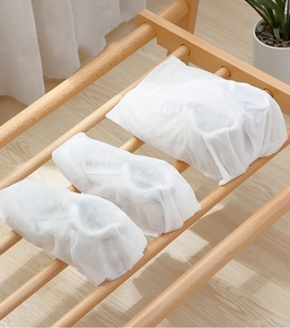 Non-woven dust bags for shoe storage on wooden shelf with breathable fabric detail