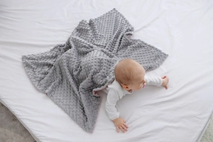 Dettaglio della coperta grigia per neonati Minky con rilievi 3D per comfort sensoriale