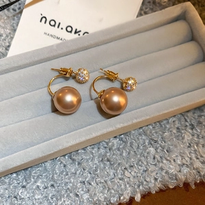 Detail of champagne gold double-sphere earrings with pearl and crystal pavé on velvet
