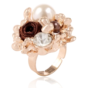 Détail macro de bague réglable avec rose en tissu marron, perle blanche et cristaux