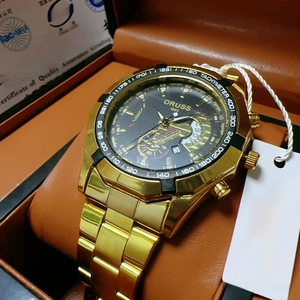 Detailed close-up of ORUSS gold chronometer watch dial with tachymeter and steel strap