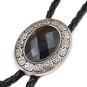 Detailed view of black faceted agate gemstone set in silver floral frame on bolo tie