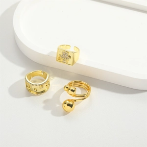 Three gold adjustable rings with Hamsa hand and hollow patterns on a white tray