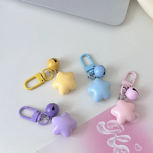 Detail of colorful star keychains featuring bells and matte hardware in various candy colors