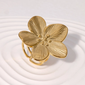French vintage gold-plated flower ring with brushed texture on a wavy display tray