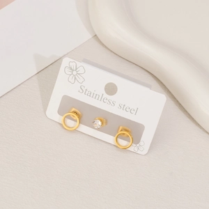 Detailed macro view of gold-plated stainless steel hoop earrings and sparkling zircon studs