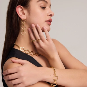 Golden stainless steel jewelry set featuring chain necklace, bracelet, and circular earrings