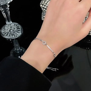 Elegant adjustable silver bracelet featuring cubic zirconia flower and circle geometric charms