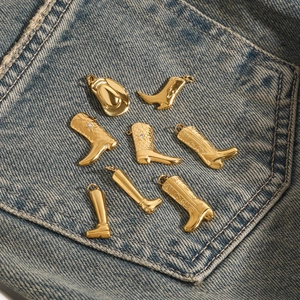 Golden western cowboy hat and boots metal charms set displayed on blue denim fabric