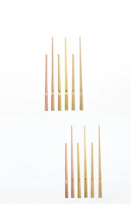 Detail view of quartz clock hands set in rose gold, gold, and bronze metallic finish