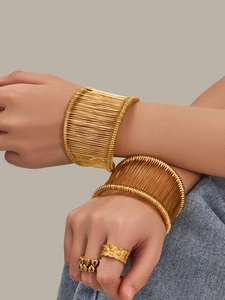 Détails de bracelets manchettes dorés en fils métalliques et bagues mode ornementées