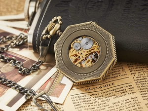 Detail of vintage octagonal mechanical pocket watch with skeleton back on old newspaper