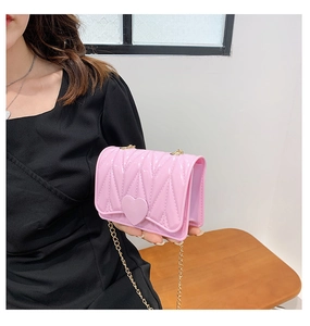 Detailed view of pink heart buckle and quilted texture on silicone mini crossbody bag