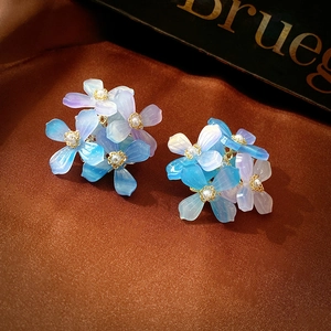 Detailed close-up of blue-purple gradient acrylic flower earrings with pearl centers