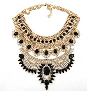 Detail of bohemian gold statement necklace with black gemstones and crystal accents