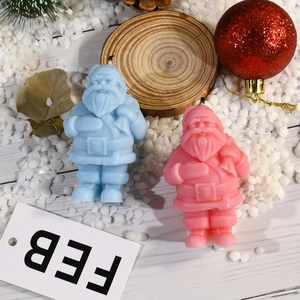 Detail von rosa und blauen Weihnachtsmann-Kerzen mit feiner Bart- und Gürtelstruktur