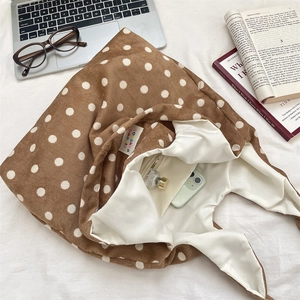 Close-up of the brown corduroy tote bag showing spacious interior and polka dot texture