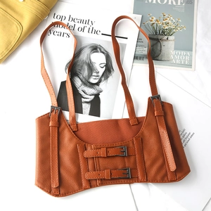 Detail of brown faux leather waist corset with adjustable buckles on fashion magazine background