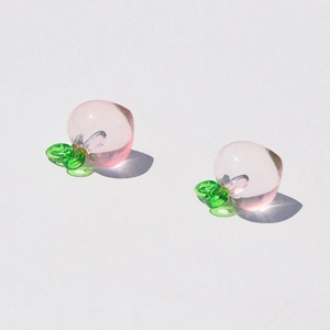 Macro shot of two transparent pink acrylic peach charms for DIY jewelry making