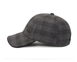 Close-up of dark grey textured wool baseball cap with curved brim and side metal logo