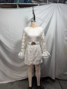 Detail of elegant white lace dress with bell sleeves and a gold buckle belt