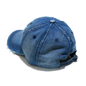 Detail of vintage washed denim baseball cap featuring distressed edges and adjustable buckle