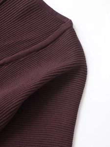 Dettaglio della trama a costine verticali su un completo in maglia color bordeaux