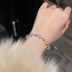 Detailed view of silver zircon bracelet with star charms and chalcedony flower stones