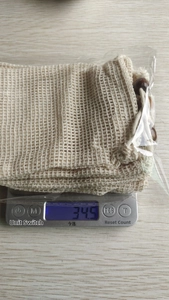 Close-up of beige jute soap bags with woven texture displayed on a digital scale