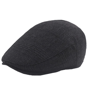 Detailed view of the dark grey woolen plaid texture and stitching on the newsboy cap