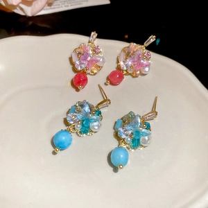 Detail of beaded butterfly earrings with freshwater pearls and colorful crystals