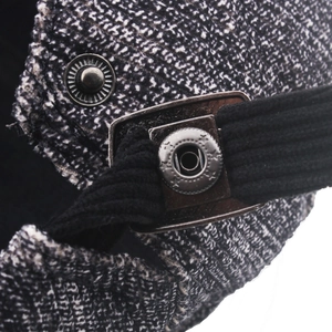 Détail du tissu en tweed avec bouton étoile en bronze et velours côtelé sur la casquette