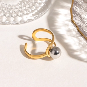 Detail of a gold adjustable open ring featuring a large grey sphere accent on textured base