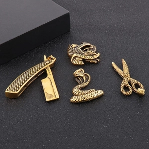 Golden hip hop pendants featuring razor, eagle, cobra and scissors on a black background