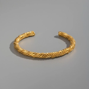 Detail of twisted rope texture and 18K gold finish on a stainless steel open cuff bracelet