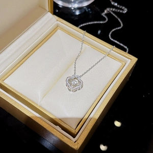 Silberne Blumenhalskette mit tanzendem Stein und Strass auf einer goldenen Box