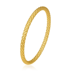 Detail of gold hollow bangle featuring a unique hammered textured finish and warm metallic glow