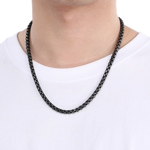 Detail of a sleek black round box chain necklace worn by a model on a white tee