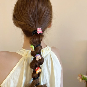 Détail d'élastiques à cheveux spirales à fleurs colorées sur une tresse bulle