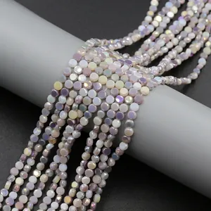 Macro detail of 4mm faceted lavender and milky white gradient glass beads with pearlescent finish