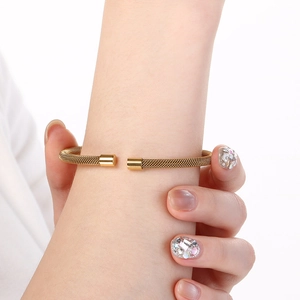 Detailed close-up of 18K gold plated mesh woven cuff bracelet with cylindrical ends
