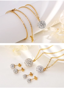 Close-up of golden necklace and stud earrings set with spherical crystal-inlaid pendants