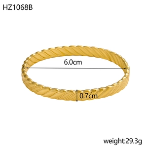 Detail view of 18K gold plated bangle with dimensions 6.0cm diameter and 0.7cm width
